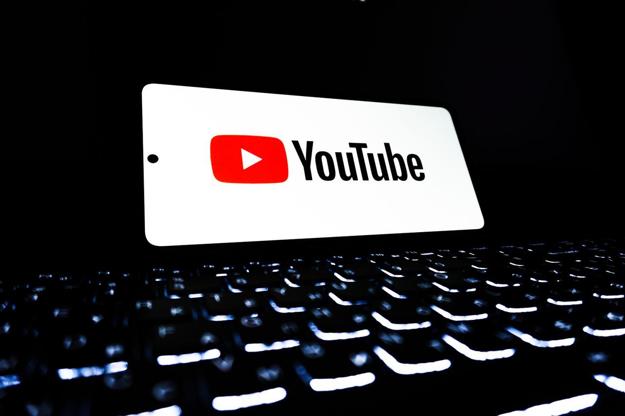 Prikaz ikone YouTube aplikacije na pametnom telefonu iznad osvijetljene tipkovnice, što predstavlja digitalne medije i online streaming.